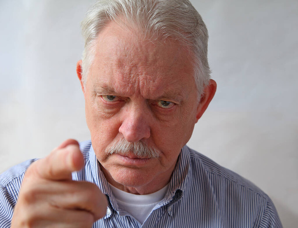 Ein wütender Senior zeigt mit dem anklagenden Finger auf das Gesicht - Foto, Bild