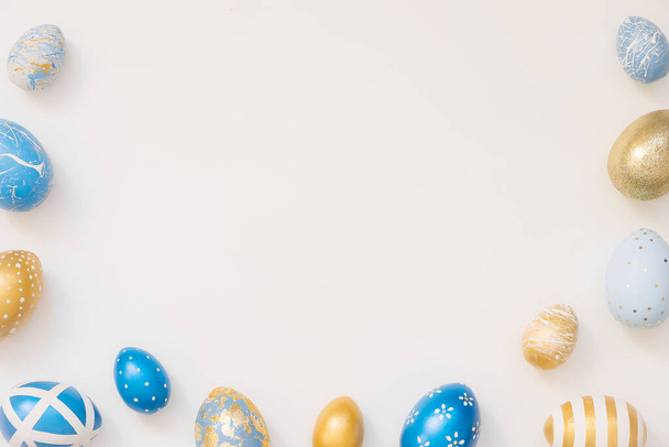 Ramka pisanek ozdobione jaja izolowane na białym tle. Minimalna koncepcja Wielkanocy. Szczęśliwej kartki wielkanocnej z miejsca na tekst. Widok z góry, płaski - Zdjęcie, obraz