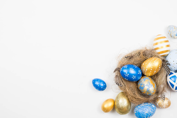 Frame of Easter golden decorated eggs in nest isolated on white background for web banner. Minimal easter concept. Happy Easter card with copy space for text. Top view, flatlay. - Фото, изображение