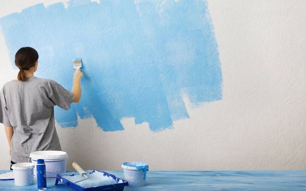 Girl puts the first layer of blue paint - Foto, Bild