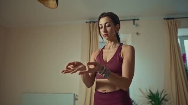 Kaunis naispuolinen joogaohjaaja osoittaa kehon käänteitä, venyttely sitten rentouttava kädet polvilla ja hengitys
. - Materiaali, video