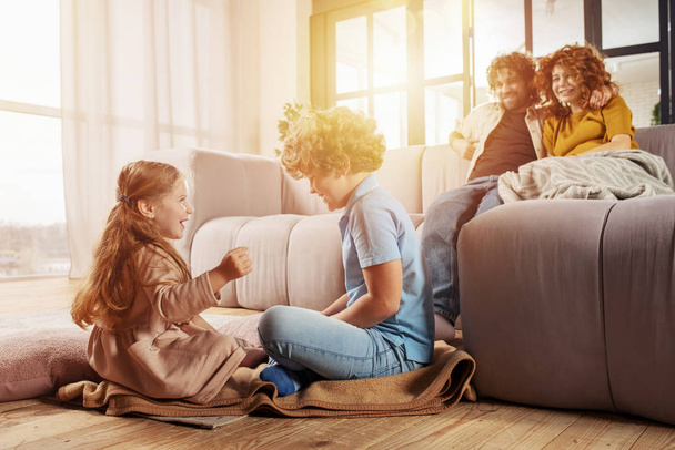 Счастливая семья играет вместе дома на диване. концепция союза, любви, привязанности
 - Фото, изображение