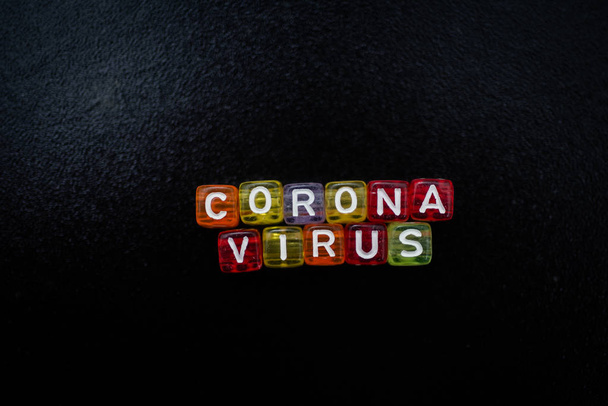 Mot coloré CORONA VIRUS cube alphabet anglais sur fond de couleur noire, mise au point sélective
 - Photo, image