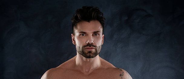 Muscular model, brunet man on dark studio background. Fashion portrait of strong guy. Sexy naked torso. - Valokuva, kuva
