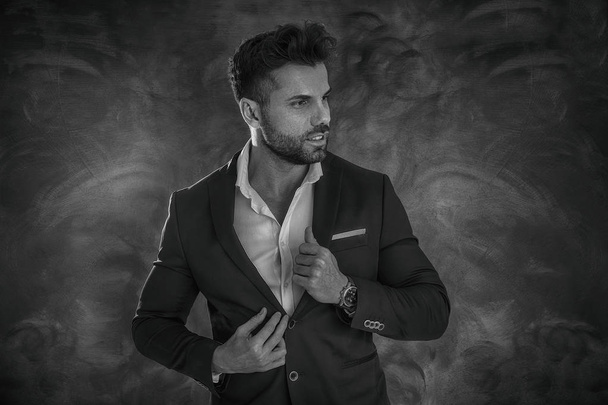 Portrait of handsome man in elegant suit on a dark background. Business style, businessman. Studio shot. - Φωτογραφία, εικόνα
