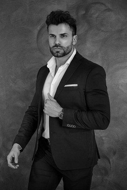 Portrait of handsome man in elegant suit on a dark background. Business style, businessman. Studio shot. - Foto, Imagem