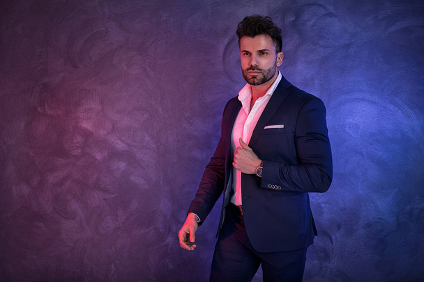 Portrait of handsome man in elegant suit on a dark background. Business style, businessman. Studio shot. - Фото, зображення