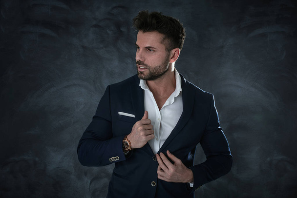 Portrait of handsome man in elegant suit on a dark background. Business style, businessman. Studio shot. - Fotoğraf, Görsel