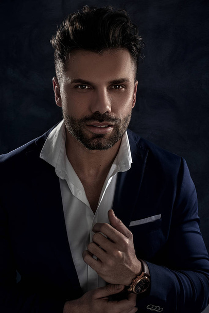 Portrait of handsome man in elegant suit on a dark background. Business style, businessman. Studio shot. - 写真・画像
