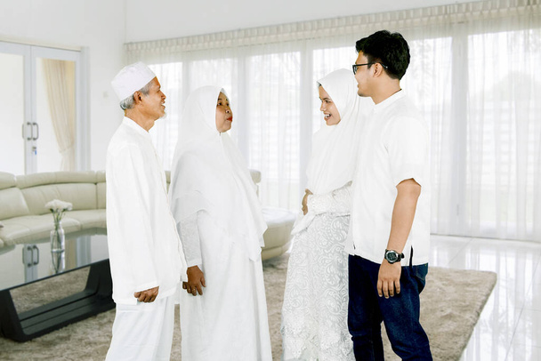 Ouders met zoon en dochter praten samen tijdens Eid Mubarak viering thuis - Foto, afbeelding