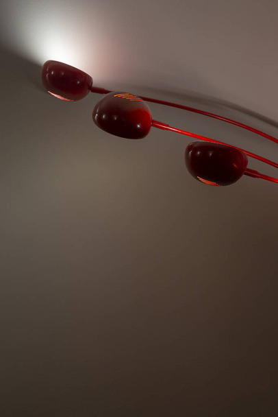 изображение красной внутренней лампы с включенным светом на нейтральной стене
 - Фото, изображение