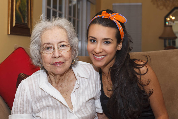 Ältere über 80-jährige Großmutter mit Enkelin im häuslichen Umfeld. - Foto, Bild