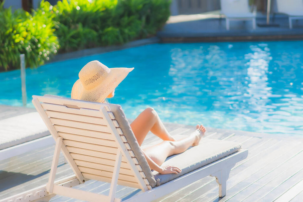 Retrato hermosa joven mujer asiática feliz sonrisa relajarse alrededor de la piscina al aire libre en el complejo hotelero para vacaciones de ocio - Foto, imagen