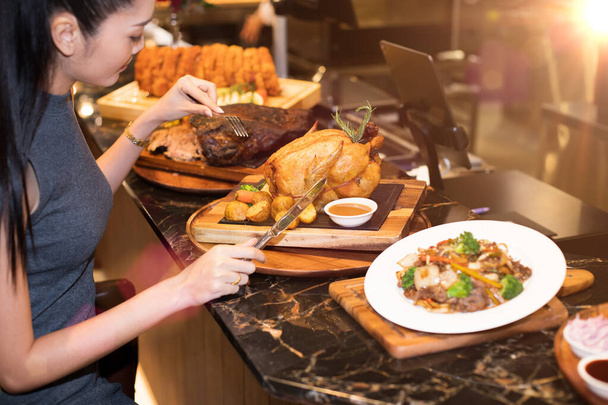 Mujer asiática trabajadora Pelo negro almorzando pavo entero Pollo Cena de comida occidental en fusión restaurante cafetería y comer solo. Concepto disfrutar de comer a mí mismo para una buena vida de comida
 - Foto, imagen