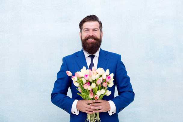 Womens day. March 8. Spring gift. Bearded man with flowers. Celebrate spring. Gentleman with tulips. Spring is coming. Romantic date. Let me invite you. Bearded man with tulip bouquet. Love date - Foto, imagen