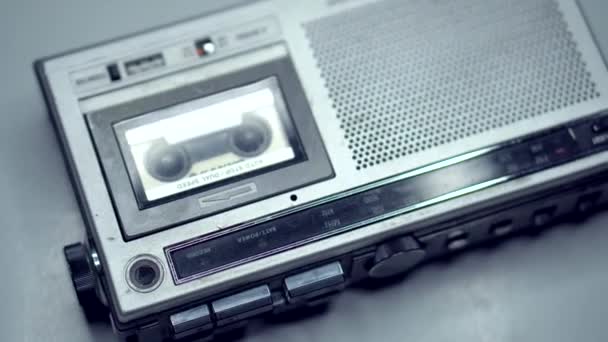 90年代に作成されたオーディオカセットレコーダーは、白いプラスチック製の卓上にあります。磁気テープに録音します。ディッタフォンだ。ヴィンテージ。専門ジャーナリストツール. - 映像、動画