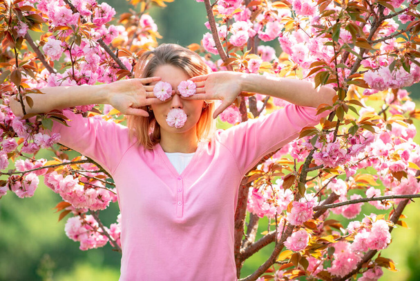 Funny girls with blooming sakura cherry Flover. Closing eyes with flovers. Hides eyes. 8 march womens day. - Fotoğraf, Görsel