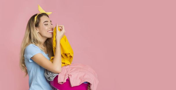 Millennial woman smelling clean clothes with pleasure - Fotó, kép