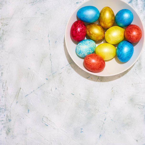 Une assiette d'œufs de Pâques décorés colorés sur le fond lumineux avec espace de copie. Vue du dessus
 - Photo, image