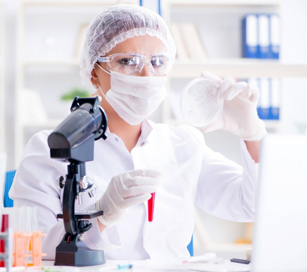 Γυναίκα ερευνήτρια επιστήμονας που διεξάγει ένα πείραμα σε ένα εργαστήριο - Φωτογραφία, εικόνα