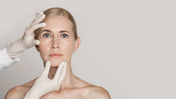Dermatologue toucher le visage de belle femme mature
 - Photo, image
