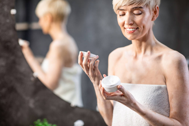 Lady Opening New Anti-Wrinkle Facial Cream Standing In Bathroom Indoor - Fotografie, Obrázek