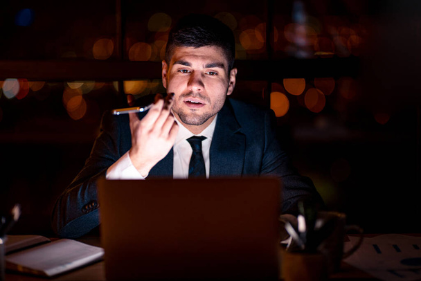 Businessman Using Voice Assistant On Mobile Phone Sitting In Office - Foto, immagini
