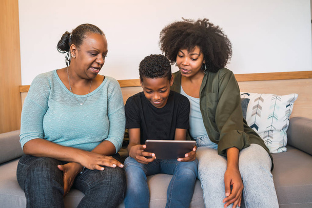 Portrait of African American grandmother, mother and son using digital tablet at home. Technology and lifestyle concept. - Φωτογραφία, εικόνα