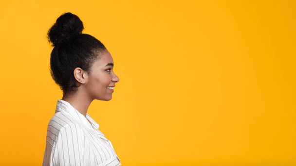 Hermoso sonriente afroamericano chica perfil retrato sobre fondo amarillo
 - Foto, Imagen