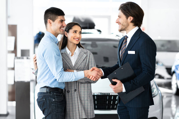 Man Shaking Hands With Car Sales Manager In Dealership Store - Foto, afbeelding