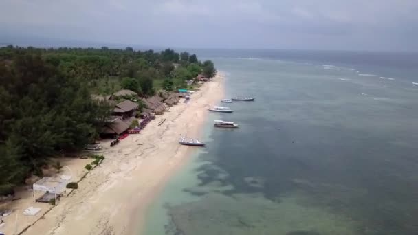 Gili Air, Indonesia: tiroteo de una isla con un dron dji saprk. En el marco de la isla, la zona de playa, barcos de transporte amarrados frente a la costa. Vistas panorámicas. Clima nublado
.  - Metraje, vídeo