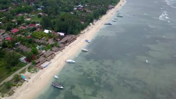 Gili Air, Ινδονησία: γυρίσματα ενός νησιού με drone dji saprk. Στο πλαίσιο του νησιού, στην περιοχή της παραλίας, τα μεταγωγικά σκάφη αγκυροβόλησαν στα ανοικτά των ακτών. Πανοραμική θέα. Συννεφιά καιρού.  - Πλάνα, βίντεο