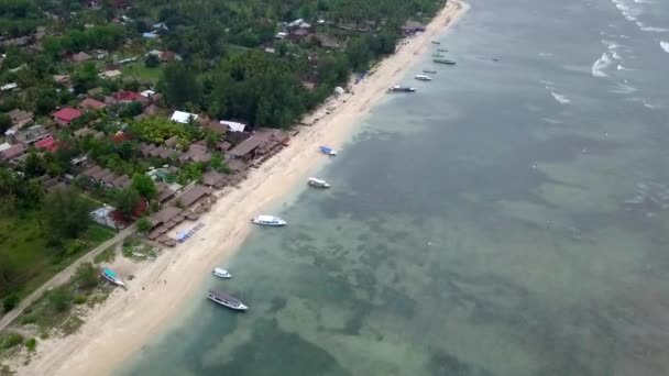 Gili Air, Indonesia: tiroteo de una isla con un dron dji saprk. En el marco de la isla, la zona de playa, barcos de transporte amarrados frente a la costa. Vistas panorámicas. Clima nublado
.  - Metraje, vídeo