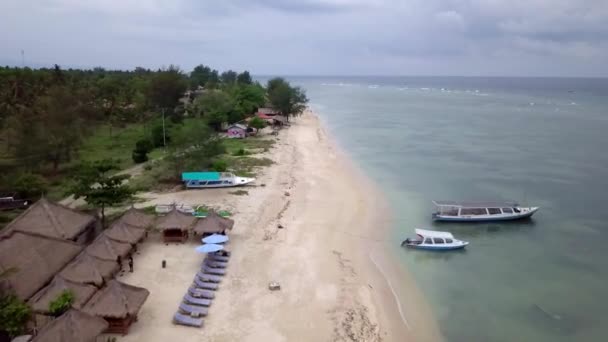 Gili Air, Indonesia: ampuminen saaren drone dji saprk. Saaren rungossa, ranta-alueella, rannikon edustalla kiinnitetyt kuljetusveneet. Panoraamanäkymät. Pilvinen sää
.  - Materiaali, video