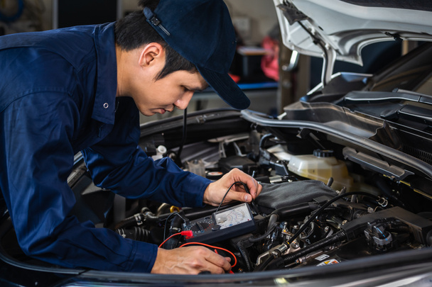 Mechaniker prüfen elektrische Verkabelung des Fahrzeugs im Autoservice - Foto, Bild