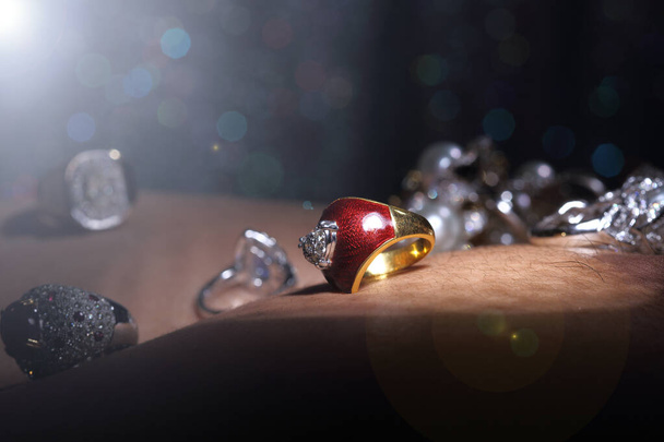 Gems, Jewelry, Daimond, Gold Silver, Ruby vavluable Rings presented put on Human Skin over Dark bokeh background with shinny object - Photo, image