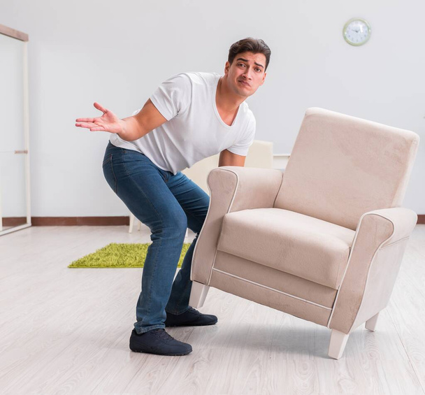 Homme déménageant des meubles à la maison
 - Photo, image