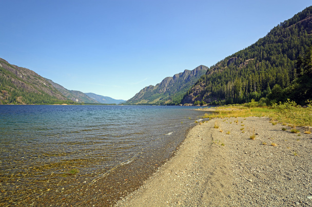Vista litorânea de um longo lago de montanha
 - Foto, Imagem