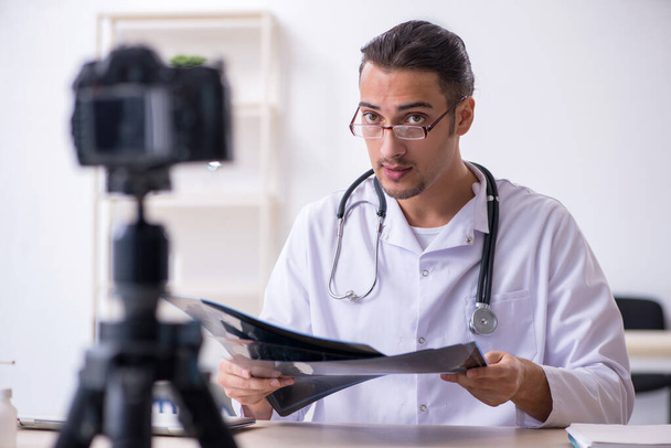 Young male doctor radiologist recording video for his blog - Foto, Imagem