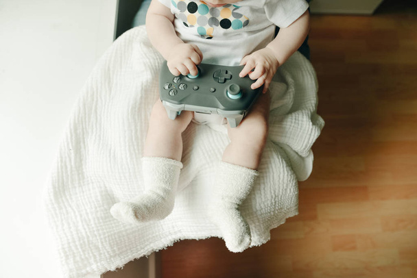 a very small child plays with the joystick - Foto, Imagen
