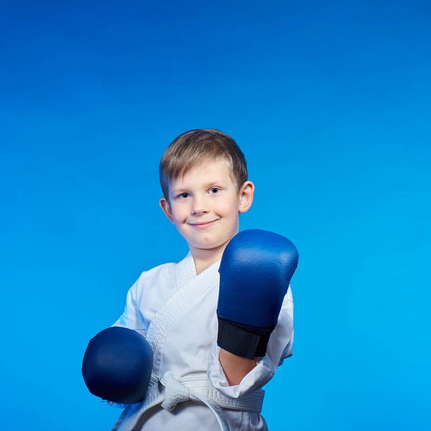 Na modrém pozadí, sportovec v karate stojanu s modrými překryvy na rukou - Fotografie, Obrázek