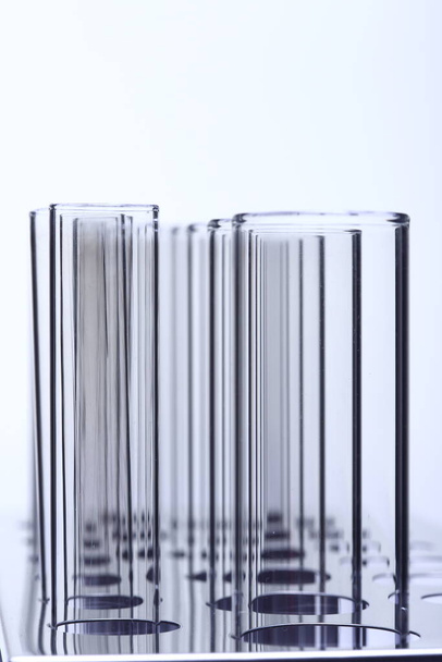 Grupo de tubo de vidrio vacío laboratorio en soporte de acero inoxidable, estudio de iluminación de fondo blanco aislado espacio de copia, primer plano
 - Foto, Imagen