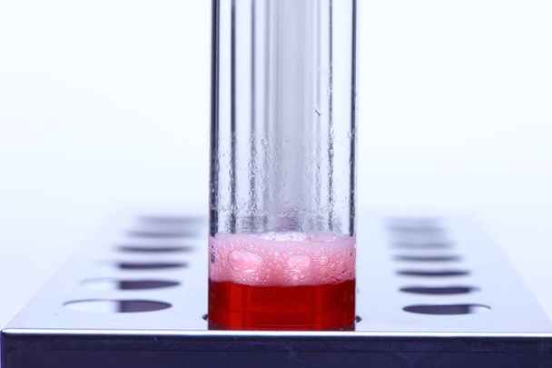 Bubble Red Liquid en grupo Herramientas de prueba de laboratorio de tubo de vidrio en soporte de soporte inoxidable, Studio iluminación fondo blanco aislado
 - Foto, imagen