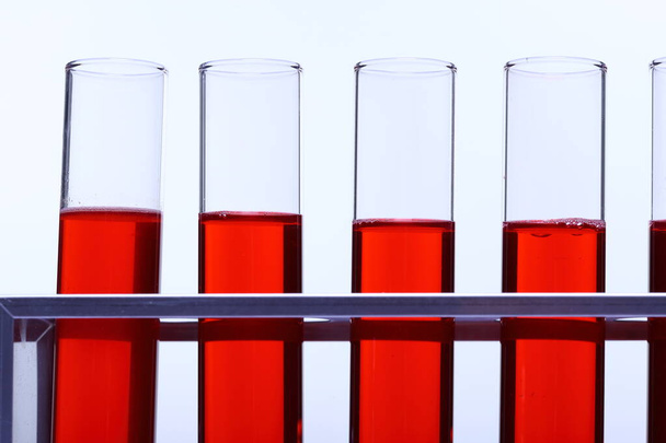Liquido rosso nel gruppo di sei strumenti di prova del laboratorio del tubo di vetro sul supporto dell'acciaio inossidabile, sfondo bianco di illuminazione dello studio isolato
 - Foto, immagini