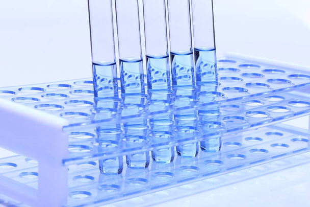 Синя рідина в лабораторних інструментах для тестування скляної трубки на пластиковому тримачі, група з п'яти, студійне освітлення білого фону ізольовано
 - Фото, зображення