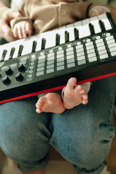 Baby voeten en piano. muzikale baby concept. - Foto, afbeelding