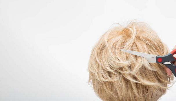 Sztuczna peruka do włosów na stojaku z drewna, oświetlenie studio na białym szarości zbliżenie detal włosów kopia logo tekstu, kolor blond curl prosta góra, profesjonalne cięcie nożyczek - Zdjęcie, obraz