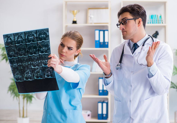 Los dos médicos que examinan las imágenes de rayos X del paciente para el diagnóstico - Foto, Imagen
