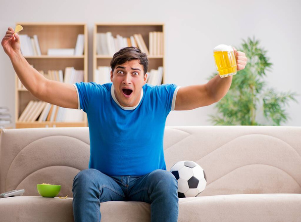 Man watching football at home sitting in couch - Foto, imagen