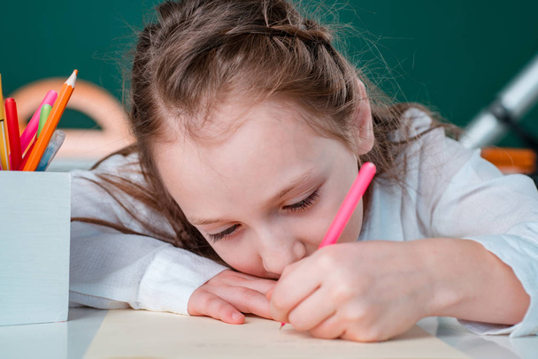Close up face. Child girl drawing picture in class. First time to school. - Foto, Imagen